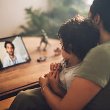 Mother and son speak to doctor with telemedicine.