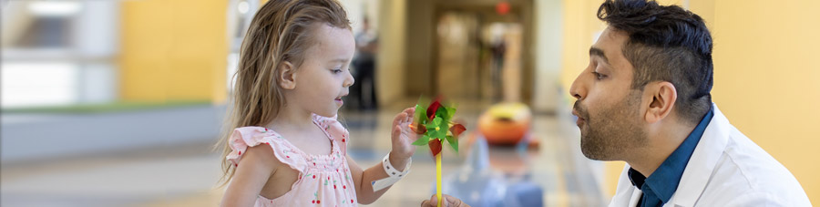Doctor give child patient a pinwheel.