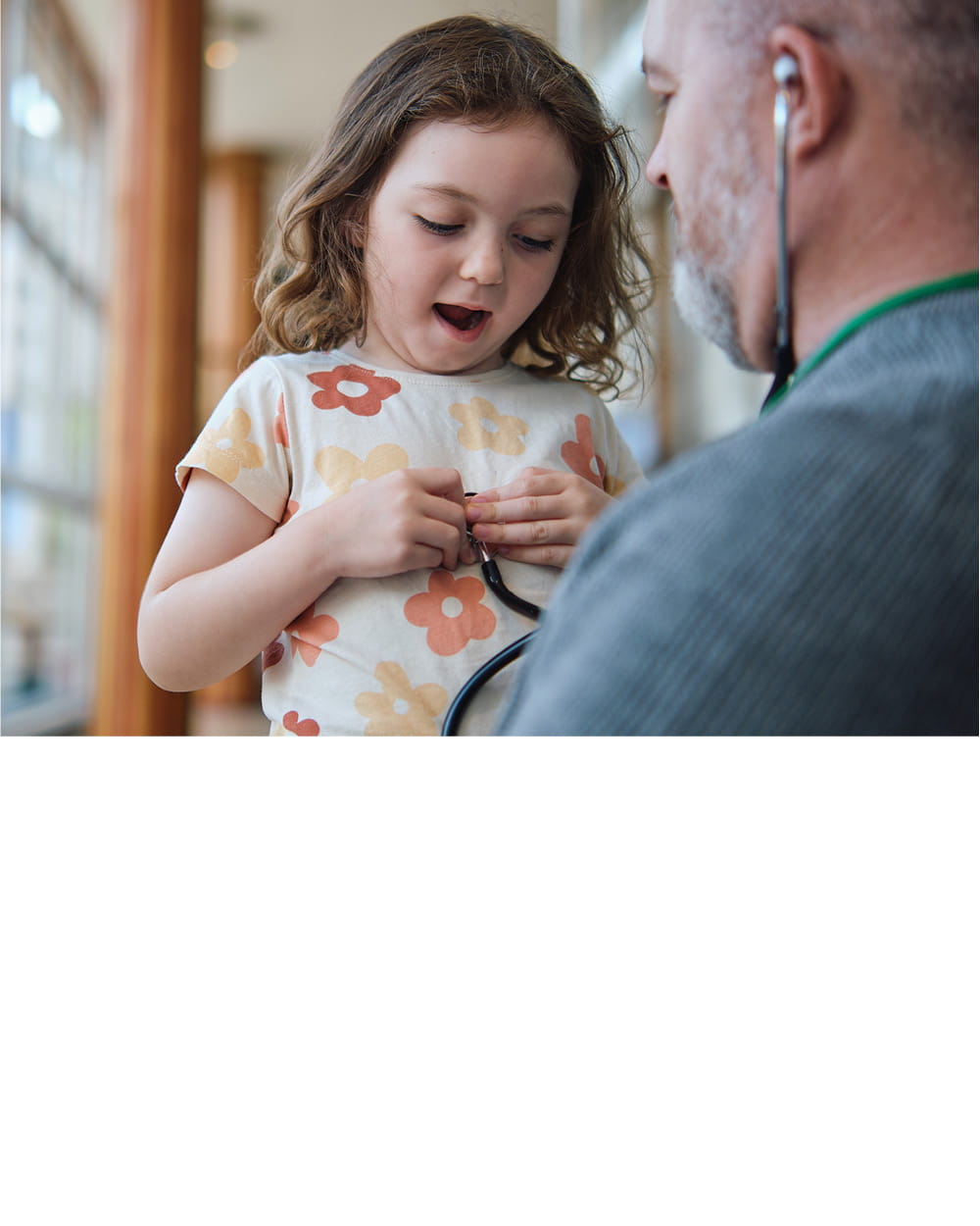 A young girl plays with a stethoscope