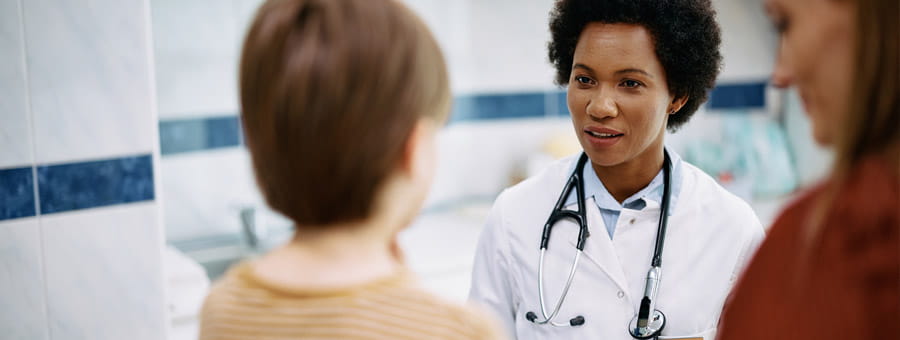 A doctor meets with a mother and her son.