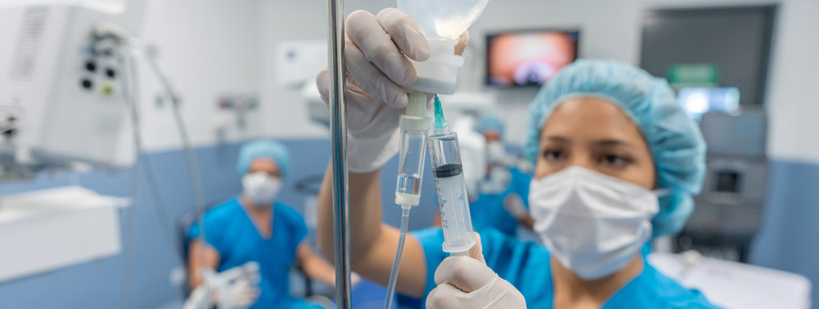 Doctor in the operating room putting drugs through an IV.