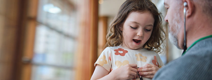 A young girl plays with a stethoscope