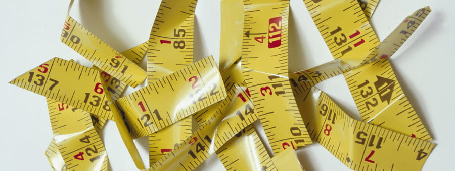 A tape measure is cut to pieces in a pile.