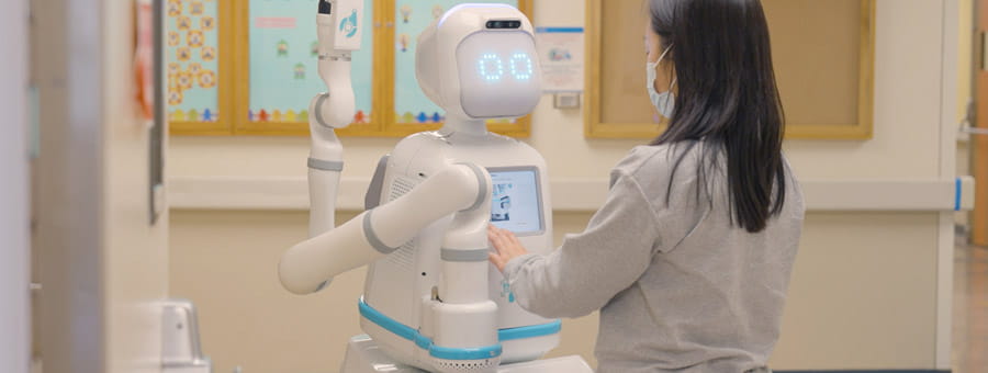 Staff interacting with Moxie the robot.