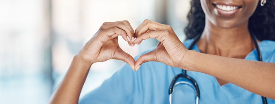 Nurse making heart shape with hands.