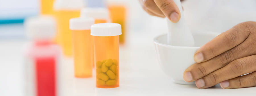 Preparing medication in mortar and pestle.