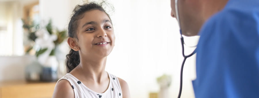 Child patient smiles at her doctor.