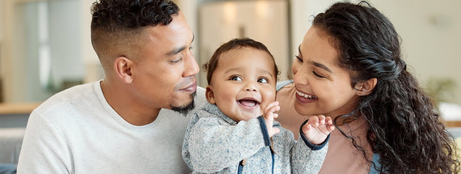 Parents snuggle their baby