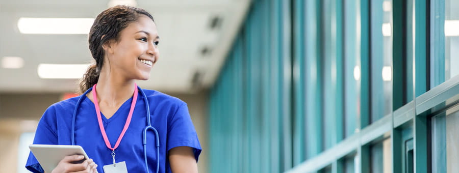 Confident young nurse walking in the hospital.