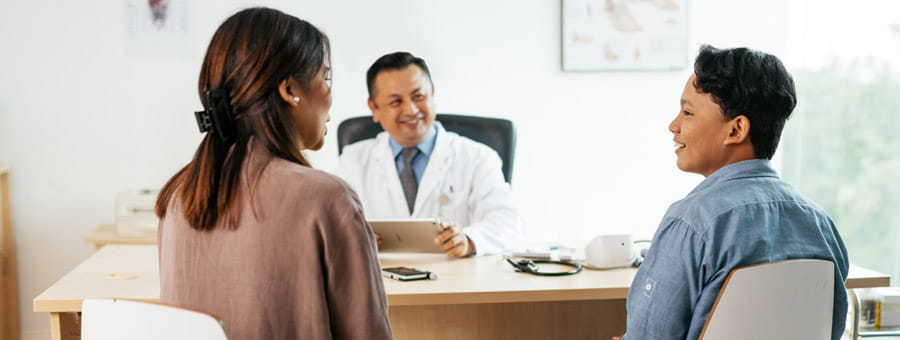 Mother and son talk with doctor.