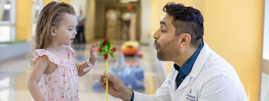 Doctor gives pinwheel to child patient.