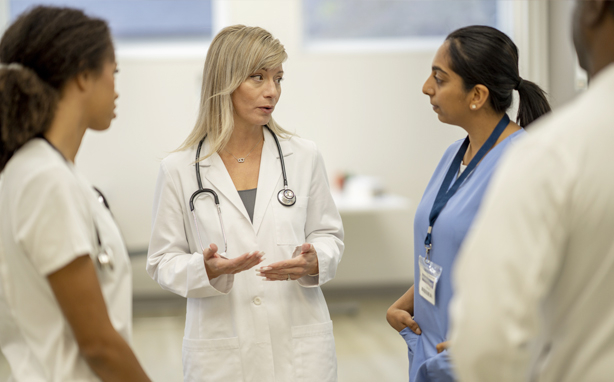 Doctors and nurses in a huddle meeting.