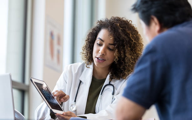 Doctors looking at patient information on a tablet.