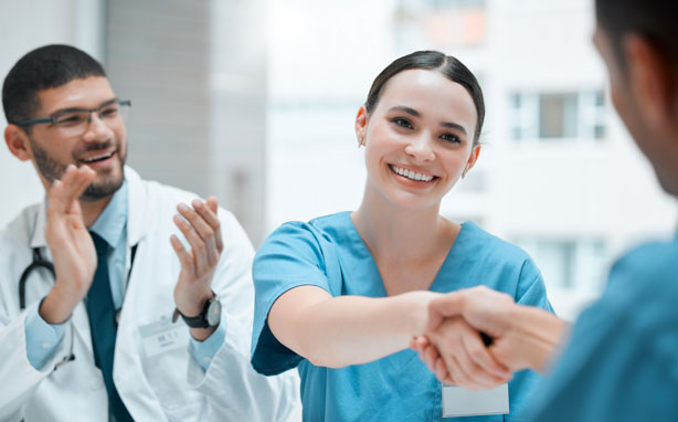 Young respiratory therapist congratulated by colleagues.