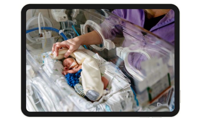 Nurse cares for baby in hospital nursery.