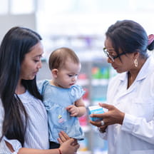 A mother with infant consults a pharmacist.