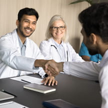 Young doctors shake hands in job interview.